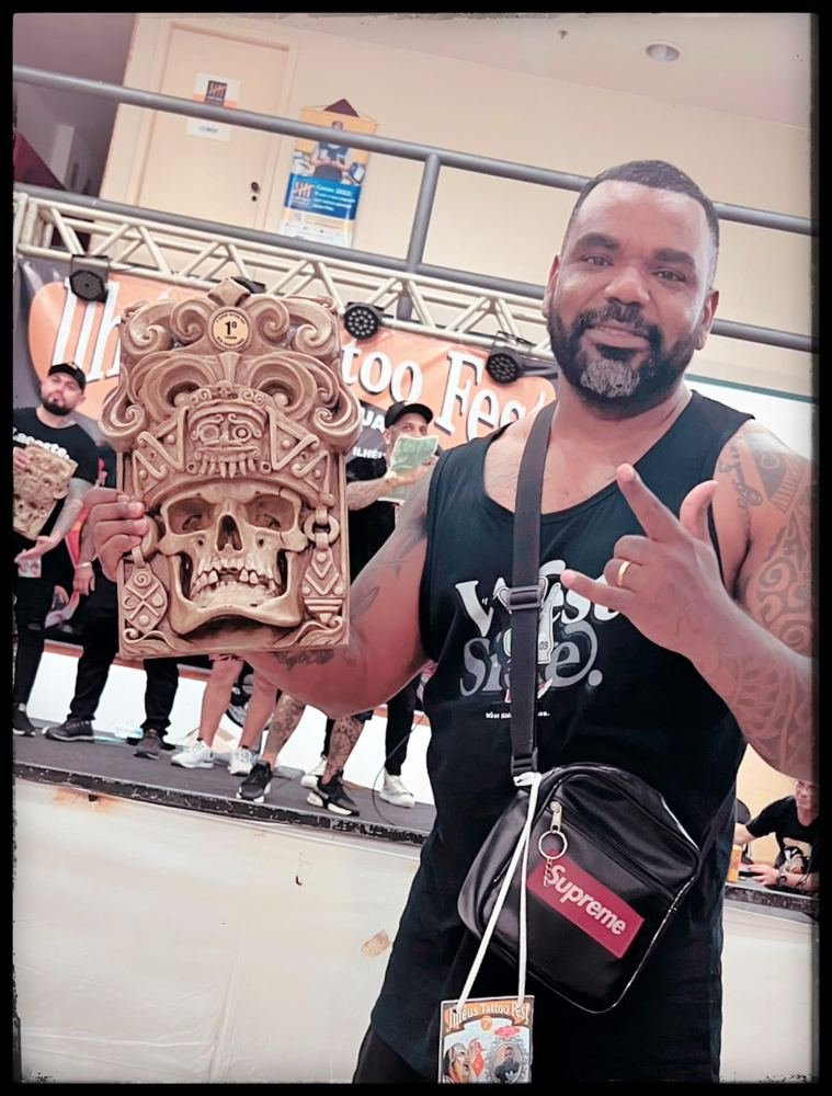 Lelo Farias com troféu de primeiro lugar em evento de tatuagem