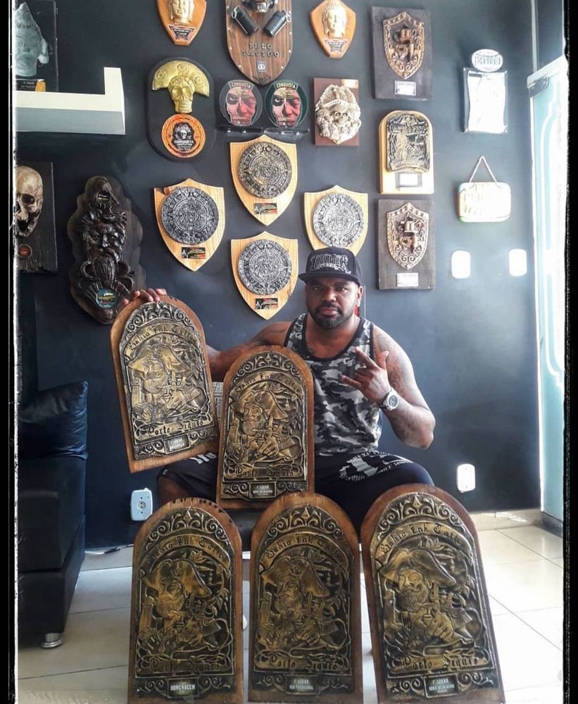 Lelo Farias diante da parede de troféus do estúdio
