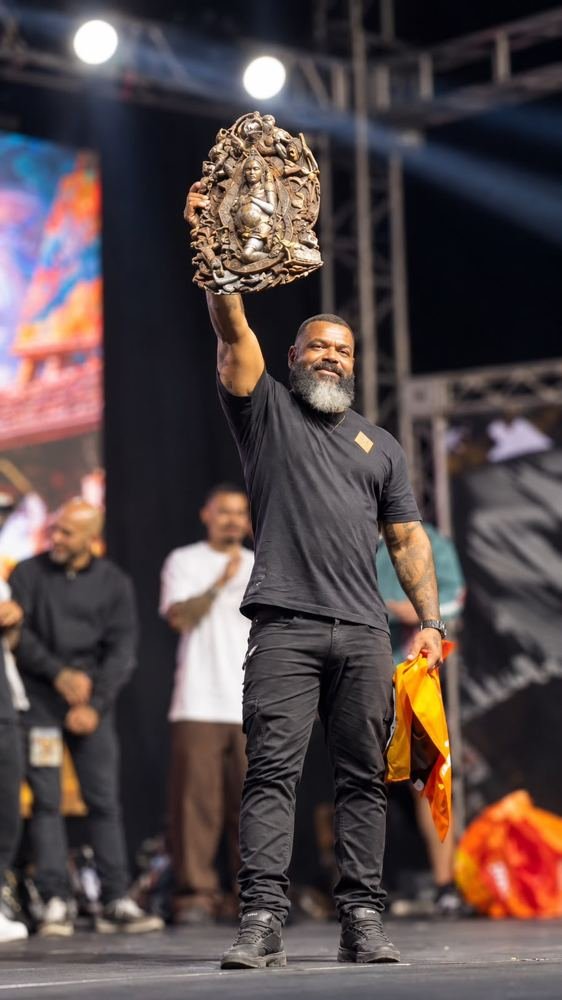 Lelo Farias no palco erguendo um troféu